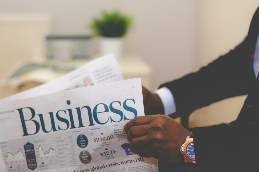 person reading a financial newspaper