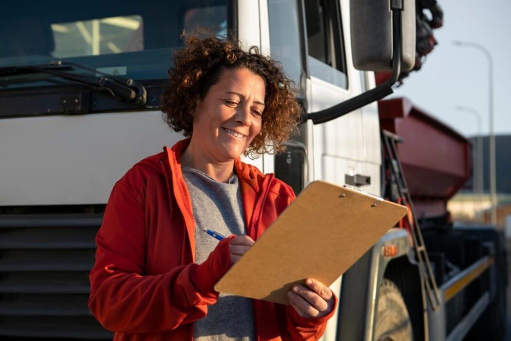 woman trucker in front of a semi truck