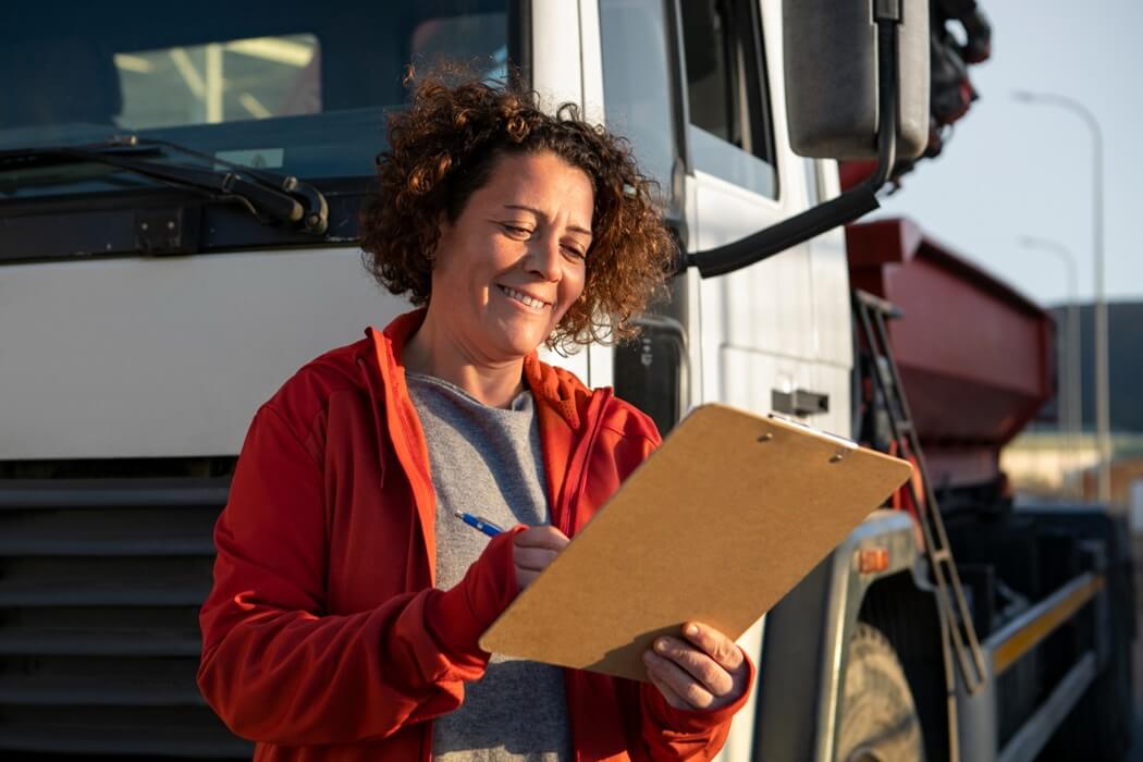 woman trucker in front of a semi truck