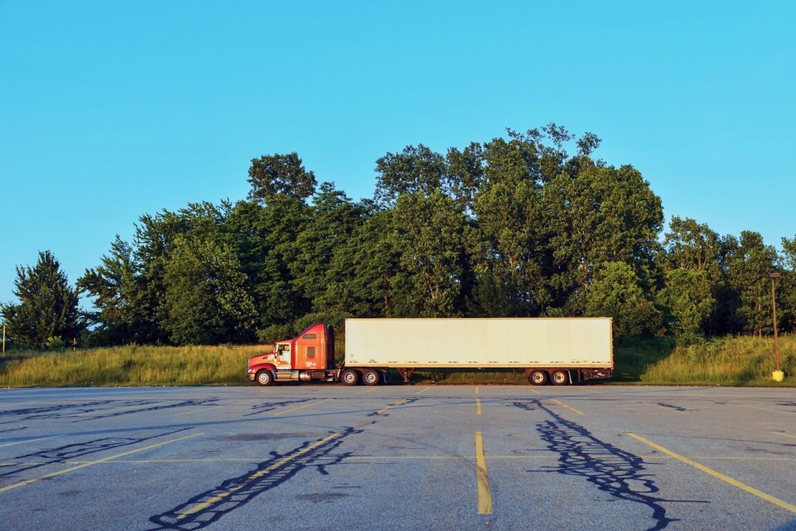 red and white freight truck in parking lot