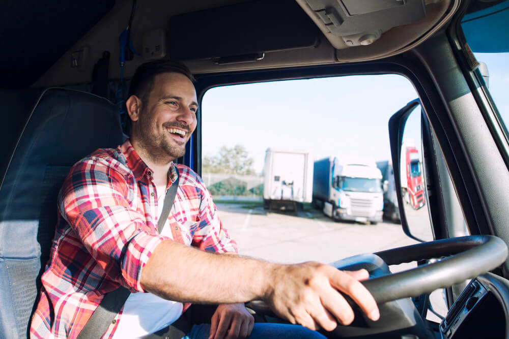 a happy truck driver driving out of the truck parking lot