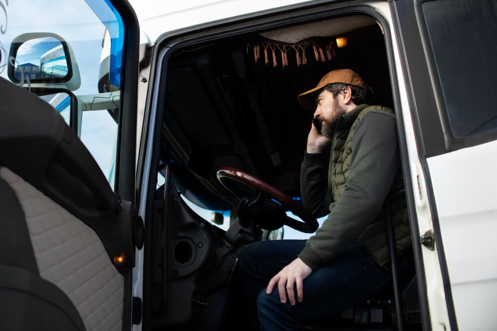 a truck driver on the phone in a truck