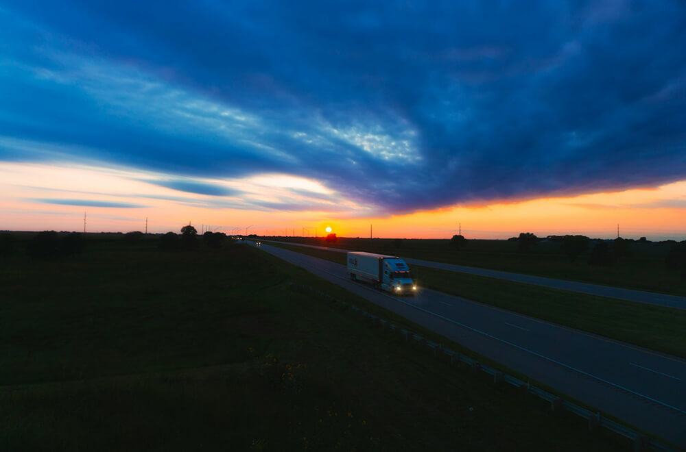 sunset over a road with a truck