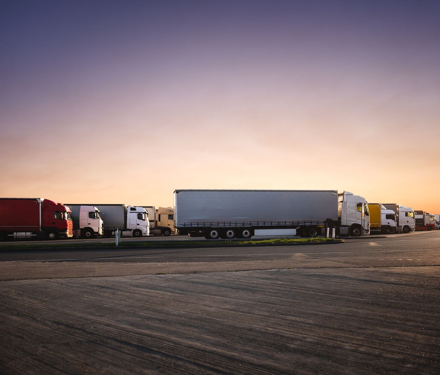 trucks parked in parking lot at sunrise